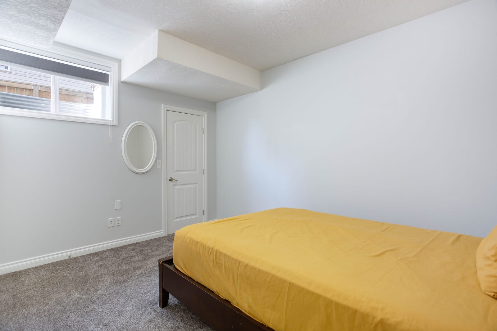 Lower-level bedroom with yellow bedding