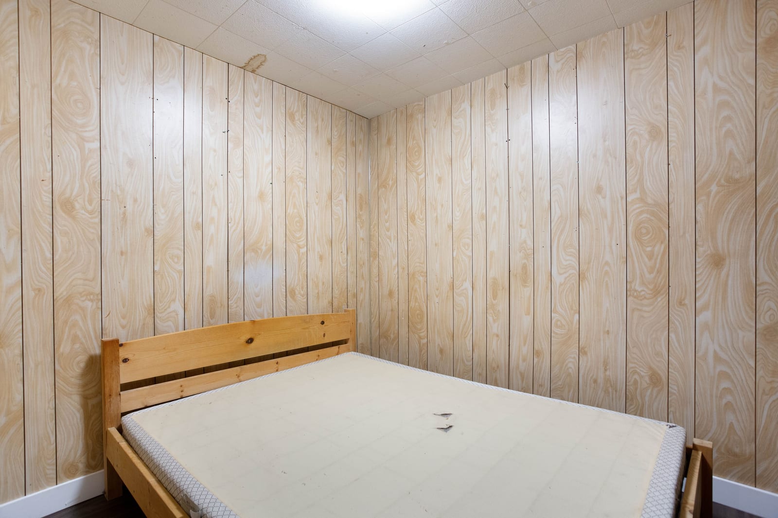 Lower-level room with wood-panel walls
