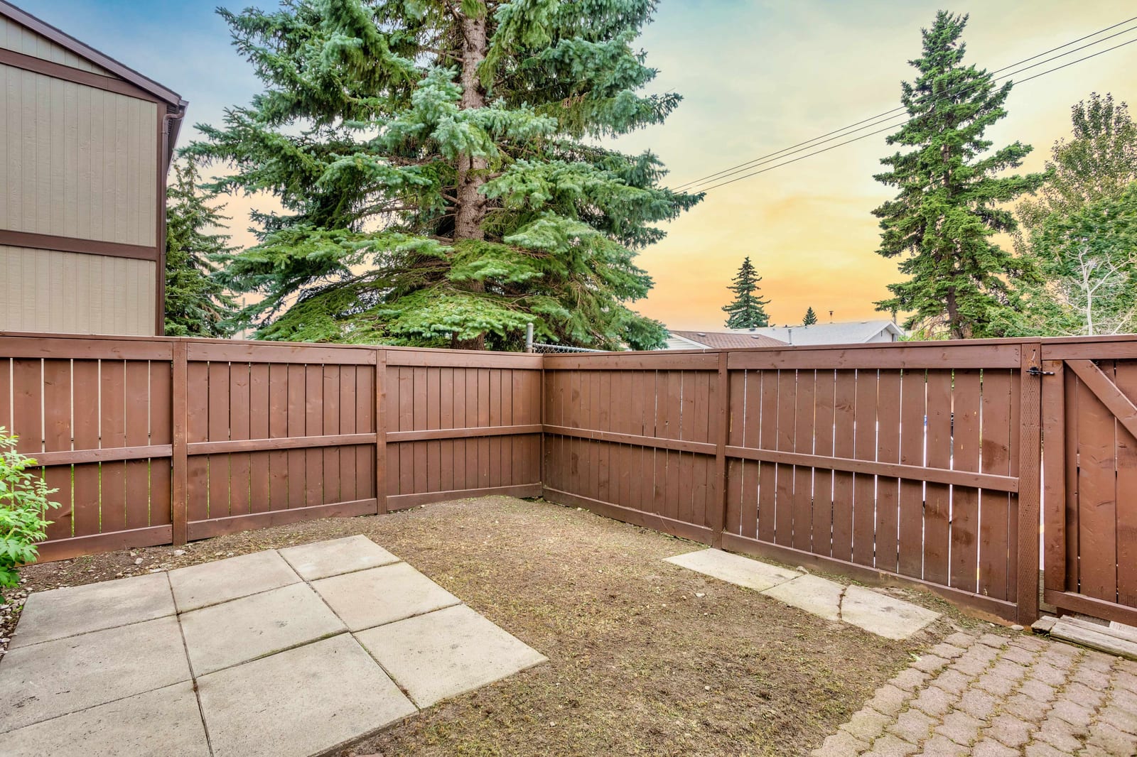 Fenced backyard with paved sitting area