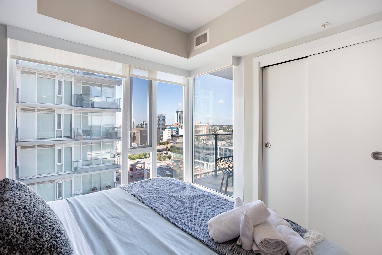 Bedroom view toward balcony and neighbouring tower