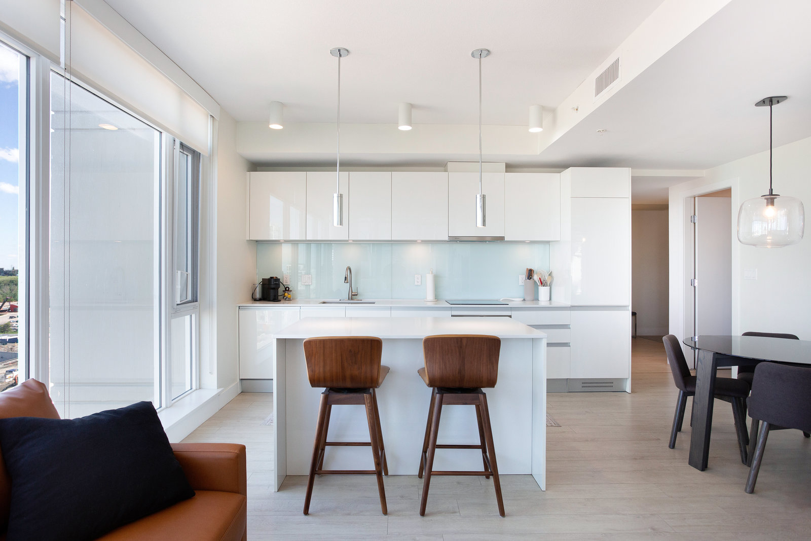 Open kitchen with island seating and glazed balcony door