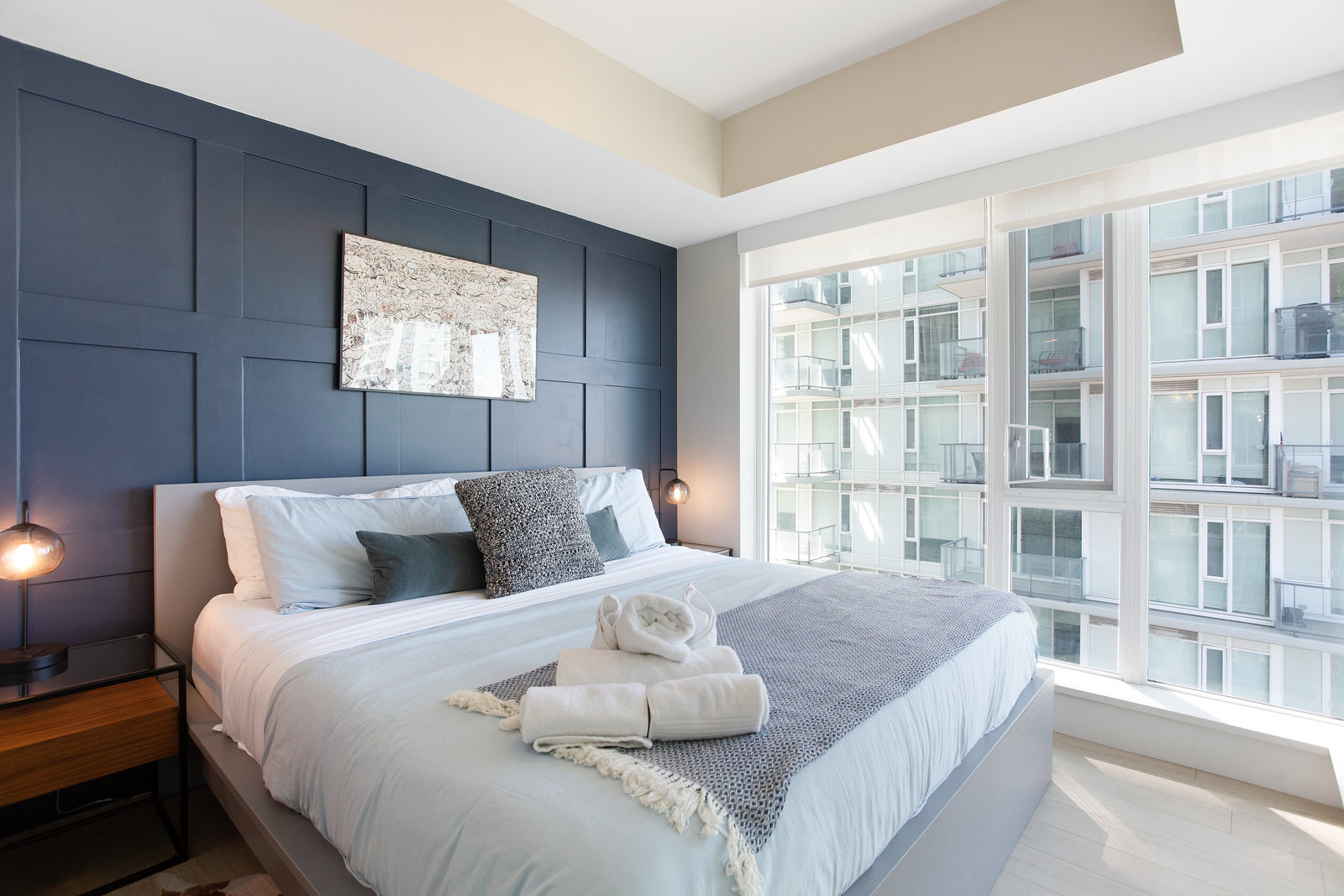 Bedroom with blue accent wall and corner windows