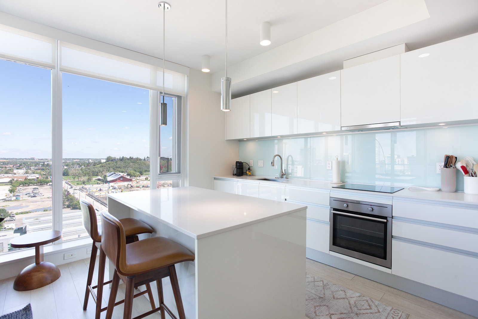 Window-lined kitchen with white cabinetry and island seating