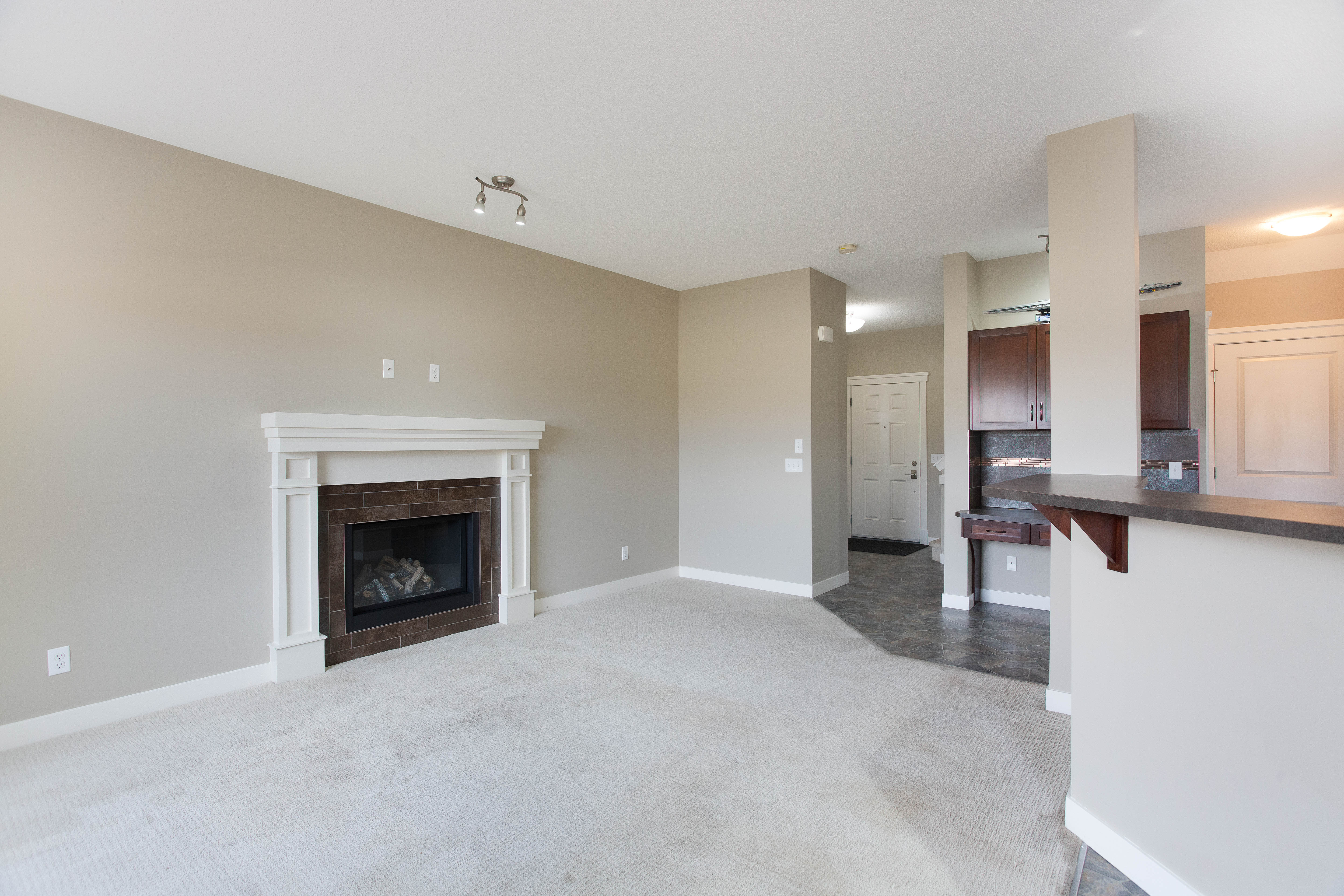 Living room fireplace and circulation — 119 Sage Hill Green NW