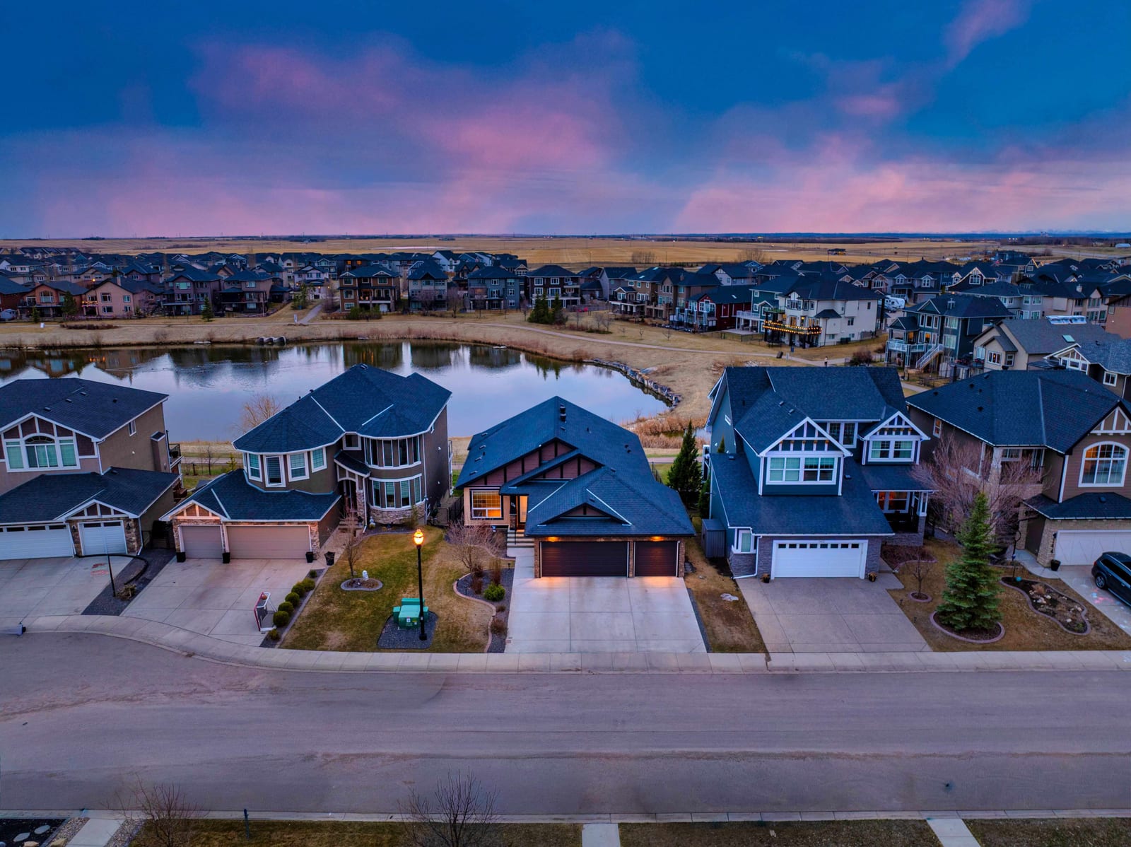 Twilight aerial view of Rainbow Falls homes and pond