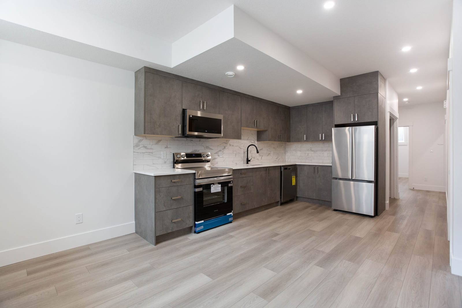 Lower-level kitchen with stainless steel appliances — supplied paired-home gallery; confirm 1106 finishes