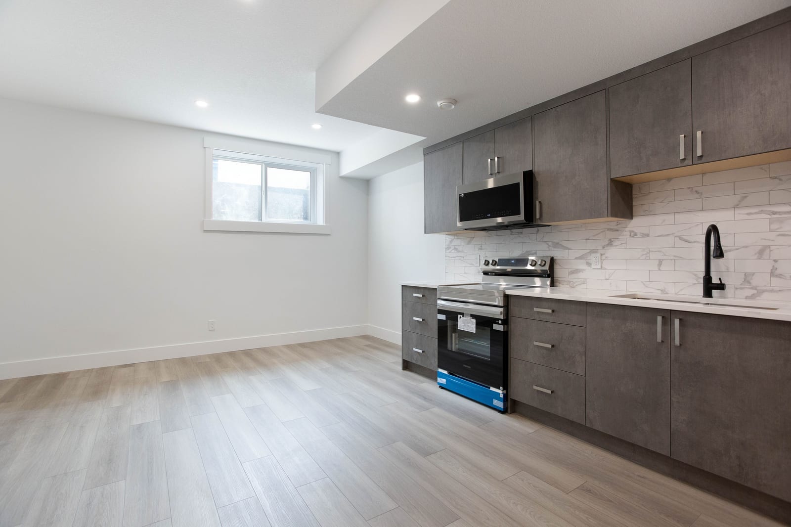 Unfurnished lower-level kitchen and living space — supplied paired-home gallery; confirm 1106 finishes