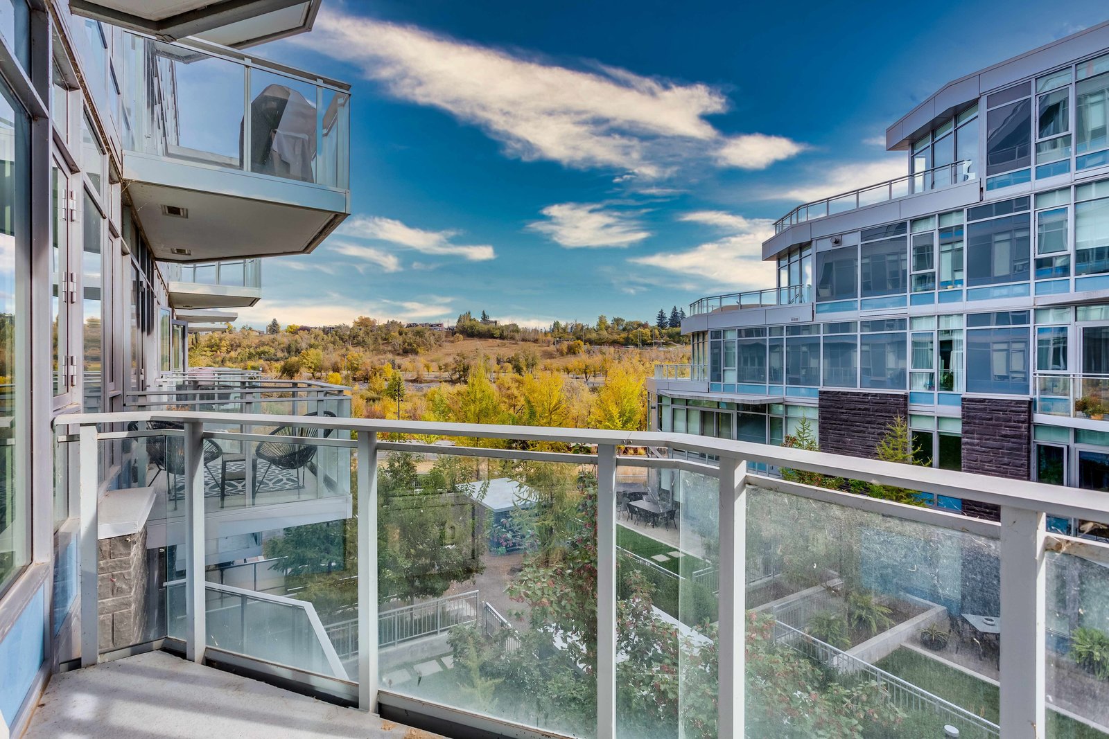 Private balcony with glass railing and courtyard outlook