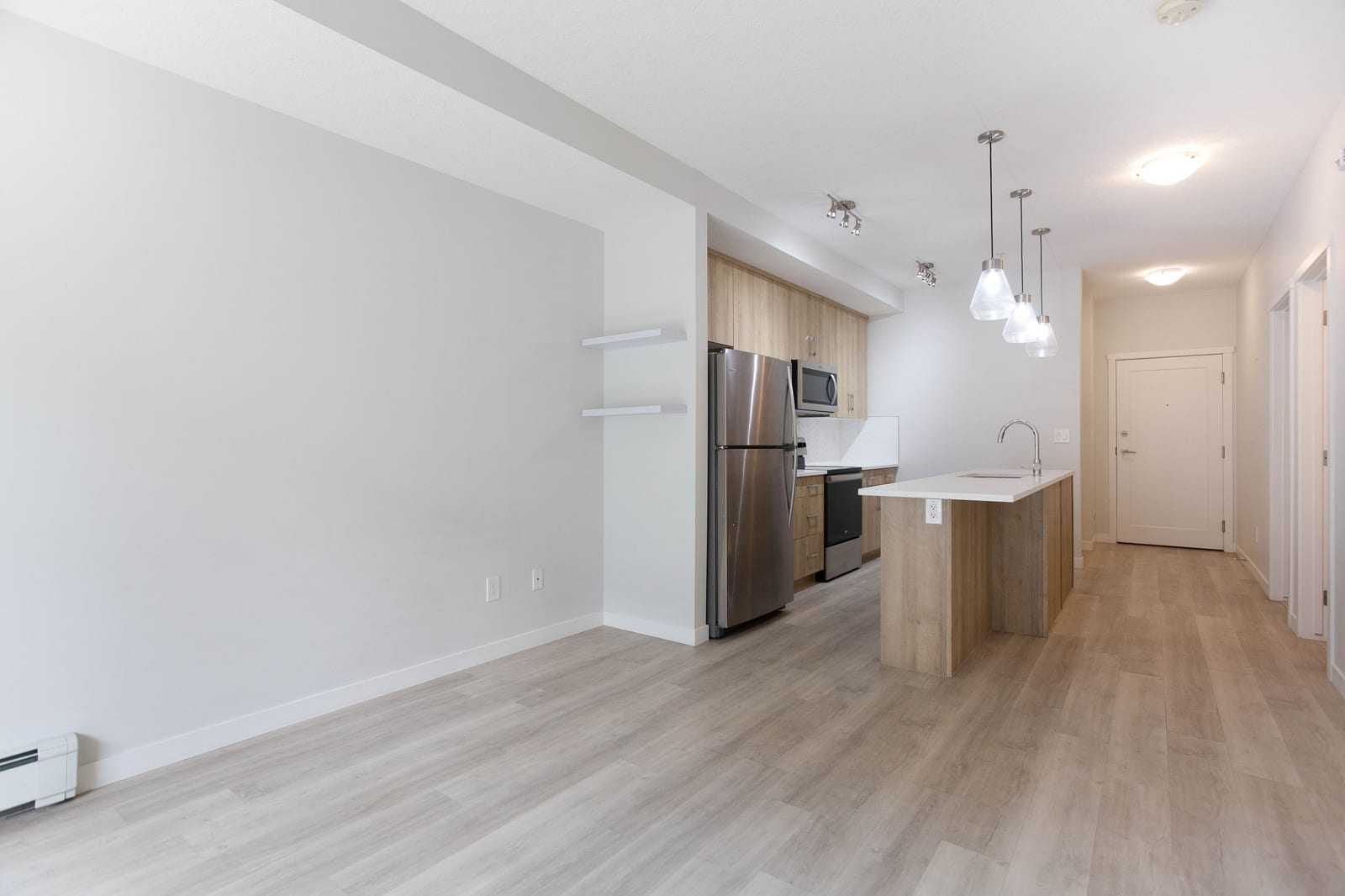 An unfurnished view toward the kitchen